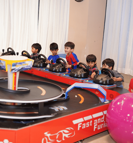 Children enjoying an exciting car racing ride at Wooray Delhi, racing around an indoor track and having fun.