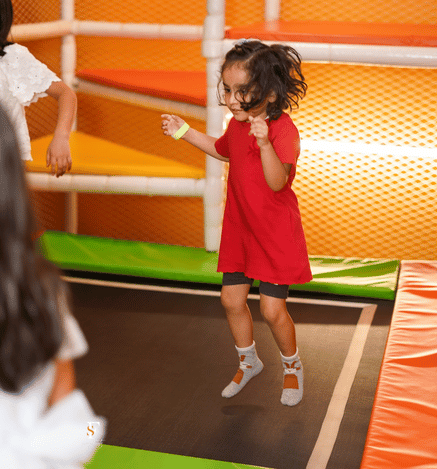 Child jumping and having fun on a trampoline at Wooray Delhi indoor play area.